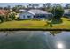 A home's exterior with a screened pool, a lawn that extends to the water, and plants are visible at 7566 Links Ct, Sarasota, FL 34243