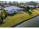 Home exterior showing a screened pool, lush landscaping, and a pond at 7566 Links Ct, Sarasota, FL 34243