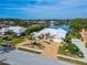 Gorgeous waterfront home boasting mature trees, a brick driveway, and a pristine white tile roof at 7566 Links Ct, Sarasota, FL 34243