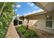 Lush landscaping along the side of the house, leading to the screened-in pool area at 7566 Links Ct, Sarasota, FL 34243