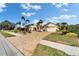 Well-maintained home featuring a large brick driveway surrounded by lush landscaping and mature palm trees at 7566 Links Ct, Sarasota, FL 34243