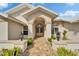 Welcoming front entrance with a brick pathway, complemented by tasteful landscaping and elegant exterior lighting at 7566 Links Ct, Sarasota, FL 34243