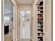 Hallway view featuring open door to storage area with shelves and nearby access to other rooms at 7566 Links Ct, Sarasota, FL 34243