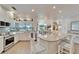 Modern white kitchen with stainless steel appliances, granite countertops, and view to living area at 7566 Links Ct, Sarasota, FL 34243