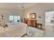 Bright main bedroom featuring light walls, tile floor, ceiling fan and sliders leading to outdoor living area at 7566 Links Ct, Sarasota, FL 34243