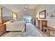 Bright main bedroom with a four-poster bed, neutral walls, and a sliding glass door to the lanai at 7566 Links Ct, Sarasota, FL 34243