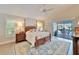 Relaxing main bedroom with a pool view, four-poster bed, and plantation shutters at 7566 Links Ct, Sarasota, FL 34243