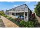 Screened pool area with beautiful landscaping surrounding it and a brick path leading to it at 7566 Links Ct, Sarasota, FL 34243