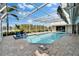 Screened-in pool area with brick pavers, an awning, and tropical landscaping at 7566 Links Ct, Sarasota, FL 34243