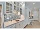 Elegant wet bar featuring glass-front cabinets, a blue backsplash, and ample counter space at 7566 Links Ct, Sarasota, FL 34243