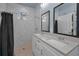 Bathroom featuring double sink vanity, large mirror and tiled walk in shower at 8716 N Brooks St, Tampa, FL 33604