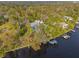 Aerial view of a luxury waterfront home with lush landscaping, boat dock, and waterway access at 906 W Henry Ave, Tampa, FL 33604