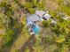 Aerial view of a home with a backyard pool surrounded by lush greenery, showcasing privacy at 906 W Henry Ave, Tampa, FL 33604