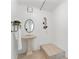 Bright bathroom featuring a pedestal sink, decorative shelf, and tiled shower at 906 W Henry Ave, Tampa, FL 33604