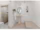 Bright bathroom featuring a pedestal sink, a decorative mirror, and tiled shower at 906 W Henry Ave, Tampa, FL 33604