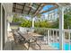 Covered deck with dining table and tropical views, overlooking a gorgeous outdoor pool at 906 W Henry Ave, Tampa, FL 33604