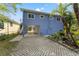 This home has a blue exterior with lush landscaping and a paver driveway at 906 W Henry Ave, Tampa, FL 33604