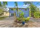 This home has a blue exterior with lush landscaping and a paver driveway at 906 W Henry Ave, Tampa, FL 33604