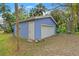 Detached garage featuring a white door and blue exterior at 906 W Henry Ave, Tampa, FL 33604