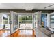 Living room with hardwood floors and French doors opening onto a covered deck with outdoor furniture at 906 W Henry Ave, Tampa, FL 33604