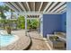 Outdoor patio area with a seating area adjacent to the pool and lush greenery at 906 W Henry Ave, Tampa, FL 33604