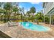 Backyard pool featuring a brick patio, lounge chairs, and lush tropical landscaping on a sunny day at 906 W Henry Ave, Tampa, FL 33604