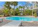 A lovely in ground kidney shaped pool surrounded by a brick patio, lounge chairs, lush landscaping, and grilling area at 906 W Henry Ave, Tampa, FL 33604