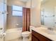 Clean bathroom with shower/tub combo and brown vanity at 929 Windton Oak Dr, Ruskin, FL 33570