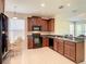 Spacious kitchen featuring dark wood cabinets and black appliances at 929 Windton Oak Dr, Ruskin, FL 33570