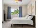 Bright bedroom with a queen bed, blue curtains, and nature-themed art at 9426 59 N St, Pinellas Park, FL 33782