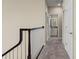 Upstairs hallway with carpet, neutral walls, and a dark wood railing at 9426 59 N St, Pinellas Park, FL 33782