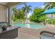 Inviting pool area with patio furniture and lush tropical landscaping at 9426 59 N St, Pinellas Park, FL 33782