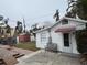 Small white guest house with red awning and wooden bench at 944 Bruce Ave, Clearwater Beach, FL 33767