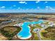 Panoramic aerial view of the community highlighting the expansive lagoon, beach areas and lush landscaping at 9804 Rowing Dale Bnd, Wesley Chapel, FL 33545