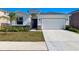 Inviting home showcasing a two-car garage, stone accents, and lush landscaping at 9804 Rowing Dale Bnd, Wesley Chapel, FL 33545