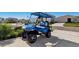 Image captures a modern blue and black golf cart, ideal for neighborhood travel and leisure at 9804 Rowing Dale Bnd, Wesley Chapel, FL 33545