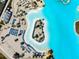 Overhead shot of lagoon with sandy beach, lounge chairs, and tiki umbrellas, providing a luxurious resort-style experience at 9804 Rowing Dale Bnd, Wesley Chapel, FL 33545