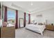 Main bedroom featuring large windows, a tray ceiling and ensuite bathroom at 9804 Rowing Dale Bnd, Wesley Chapel, FL 33545