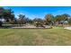 Community playground featuring swings and a slide for outdoor fun in a park setting with mature trees at 9804 Rowing Dale Bnd, Wesley Chapel, FL 33545