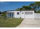 White mid-century modern home with a single car garage and fenced yard at 5601 9Th N Ave, St Petersburg, FL 33710