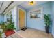 Light yellow front door with tiled entryway and landscaping at 10 N Mercury Ave, Clearwater, FL 33765