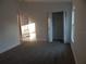 Sunlit bedroom featuring neutral carpet, closet, and a window; freshly painted and move-in ready at 10008 N 20Th St, Tampa, FL 33612