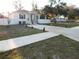 Charming single-story home with a manicured lawn, a concrete driveway, and a white picket fence at 10008 N 20Th St, Tampa, FL 33612