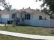 Newly built home with a brown roof, white vinyl fence, and small yard at 10008 N 20Th St, Tampa, FL 33612