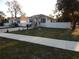 Street view of a charming home featuring manicured lawns, concrete sidewalks, and white privacy fences at 10008 N 20Th St, Tampa, FL 33612