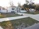 Inviting single-story home with a manicured lawn, complemented by a clean, white picket fence at 10008 N 20Th St, Tampa, FL 33612