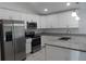 Modern kitchen with white cabinets, granite countertops, and stainless steel appliances at 10008 N 20Th St, Tampa, FL 33612