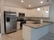 Modern kitchen featuring stainless steel appliances, granite countertops, and sleek white cabinetry at 10008 N 20Th St, Tampa, FL 33612