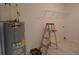 This laundry area features a modern water heater, wire shelving, and a step ladder on marble tile flooring at 10008 N 20Th St, Tampa, FL 33612