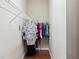 A walk in closet includes wood floors and built in shelving and hanging rods at 10757 Carloway Hills Dr, Wimauma, FL 33598